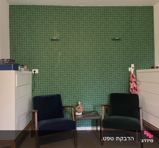 שני כיסאות מול קיר עם טפט ירוק דוגמת עיגולים